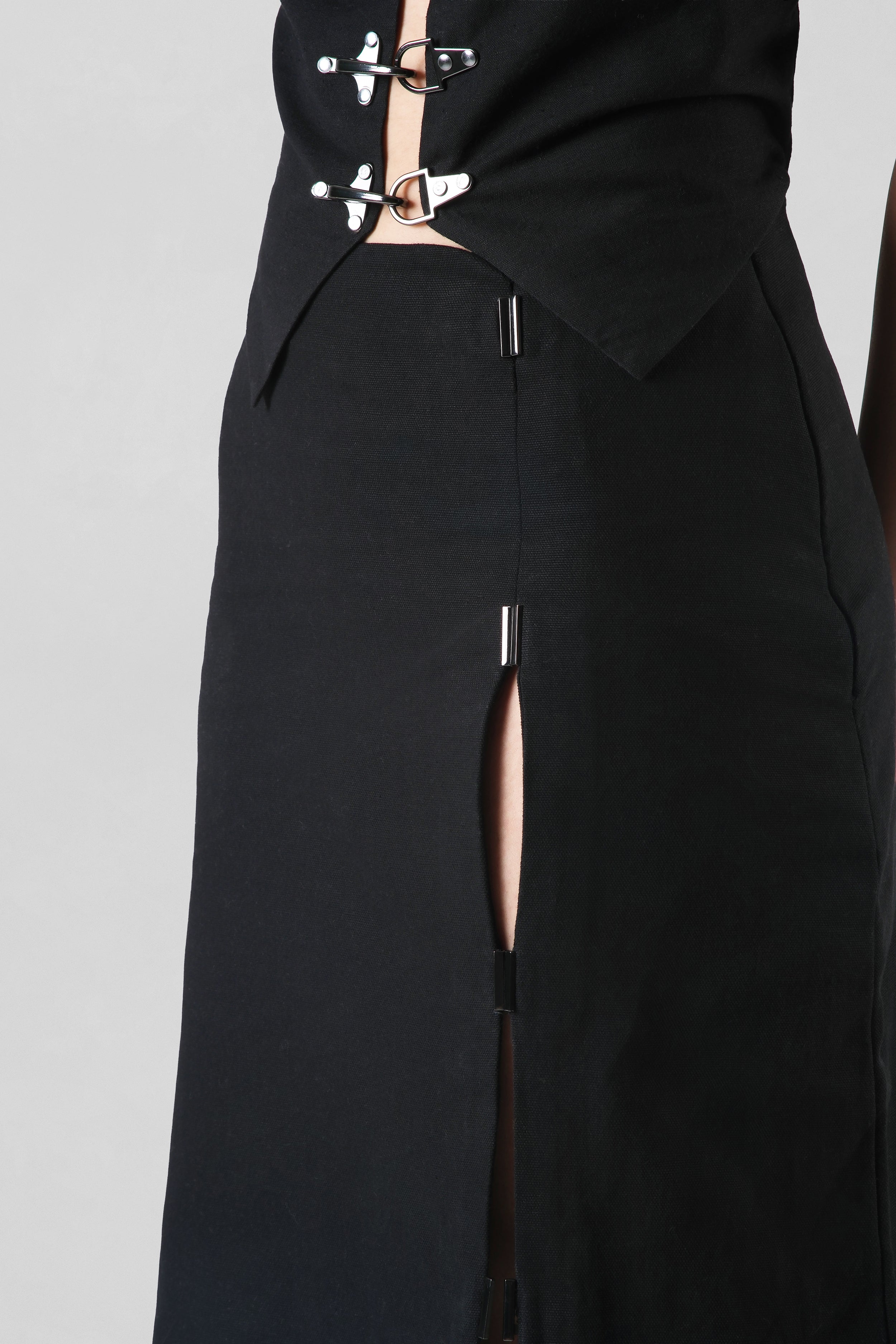 Elizabeth Skirt in black crafted from premium cotton canvas featuring a tailored midi silhouette with a contemporary front slit.