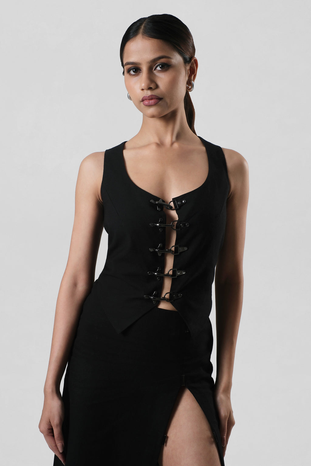 Front view of the Frida Top crafted from premium black linen featuring a sculptural sleeveless silhouette with statement hardware detailing.