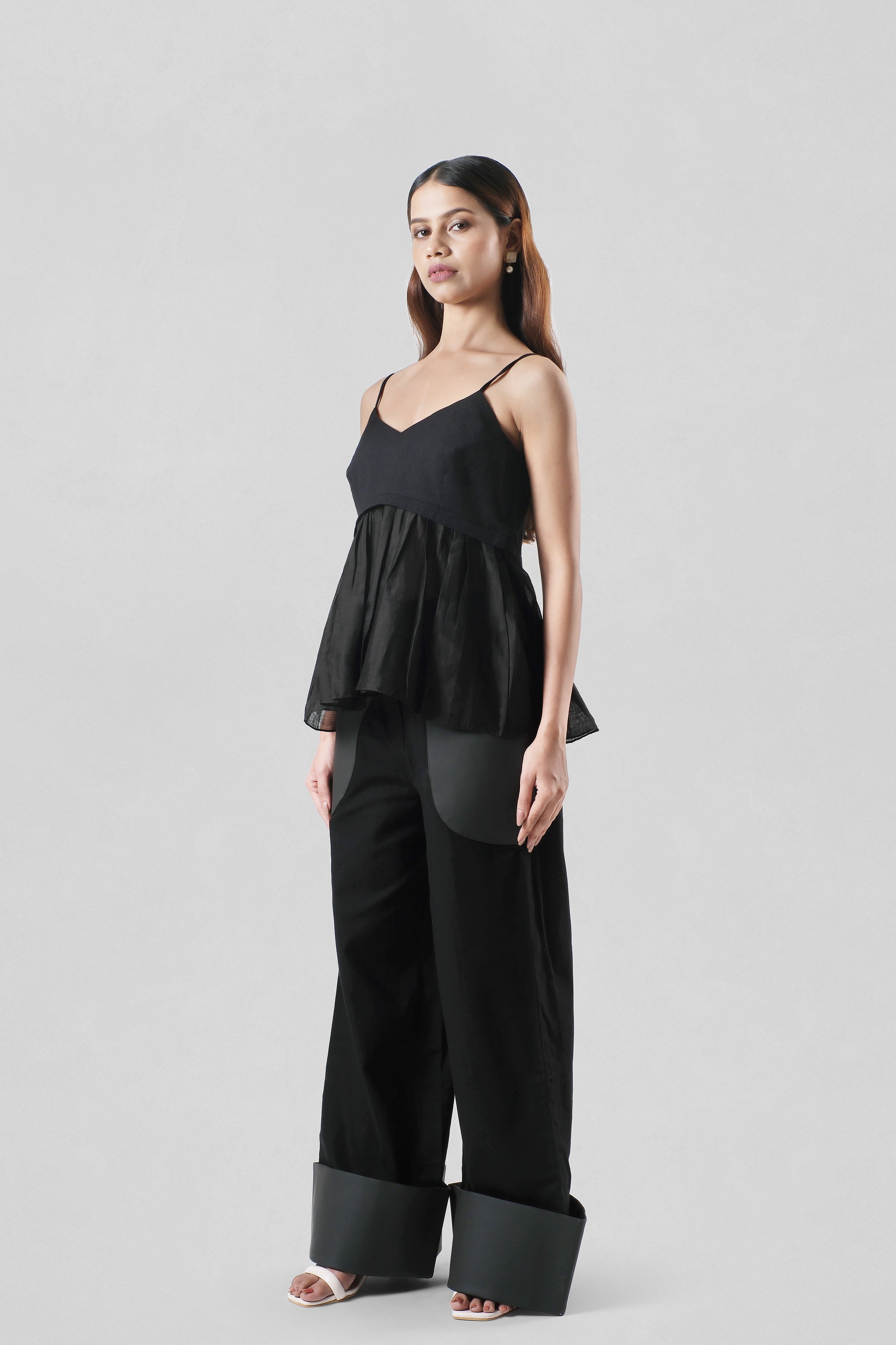 Side view of the Jane Trousers showcasing the relaxed wide-leg fit and tailored silhouette in black cotton canvas.