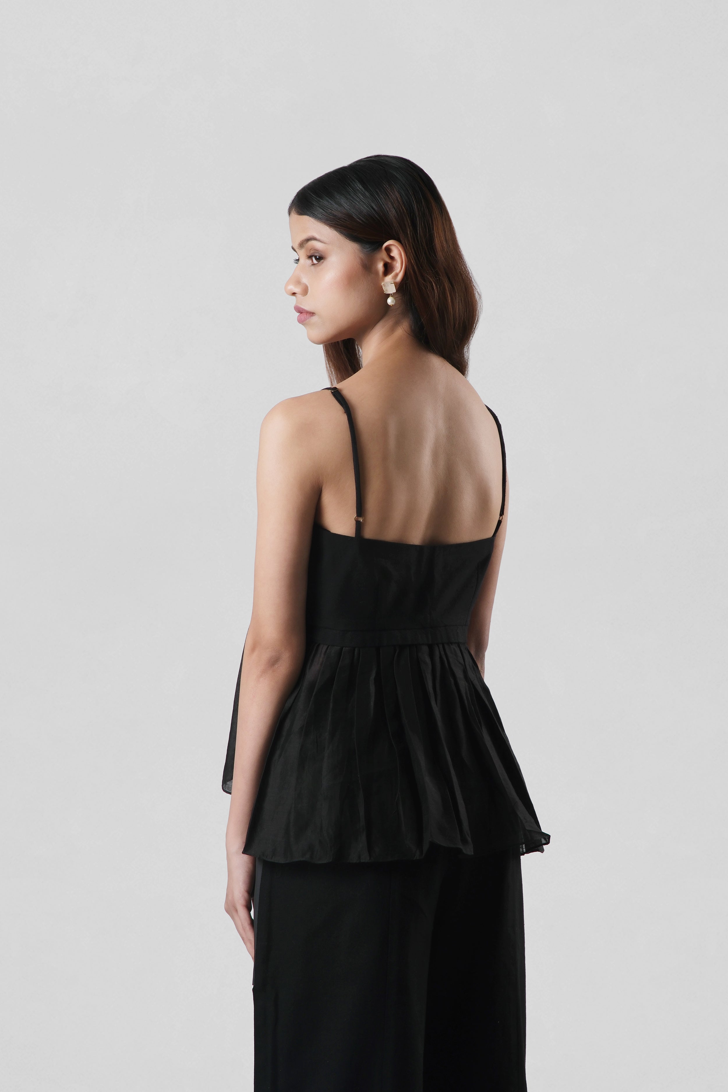 Side profile of Serena Black Peplum Top by House of Lore showcasing structured peplum silhouette